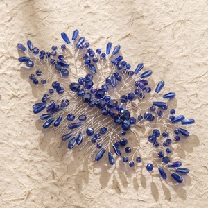 Detailed view of handmade blue crystal beads and silver wire leaf comb for bridal hair