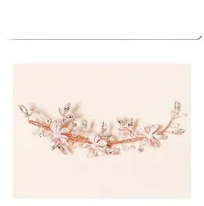 Close-up of rose gold bridal hairpiece featuring handmade flowers, pearls and crystals