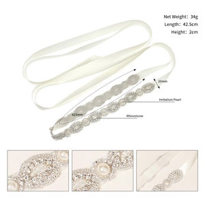 Detail view of bridal belt with white rhinestones and pearls on satin ribbon