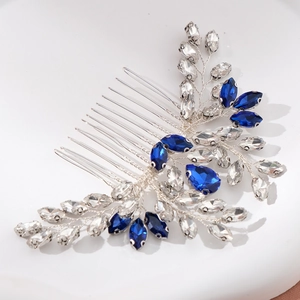 Macro shot of bridal hair comb with royal blue rhinestones and silver leaf branches