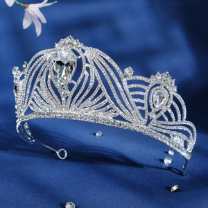 Detailed macro view of crystal bridal tiara with large teardrop center diamond on blue silk
