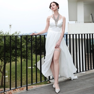 Détail de robe de mariée blanche en satin avec fente latérale et jarretière en strass brillant