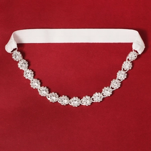 Detailed macro view of luxurious bridal garter with sparkling rhinestones on red fabric