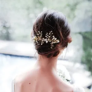 Detailed close-up of handmade bridal hair comb with gold wires and white pearls