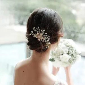 Detailed view of champagne bridal flower hairpiece with pearls and rhinestones on a bride