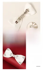 Close-up of white satin bow hair clip with sparkling rhinestones and alloy spring clip