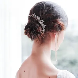 Close-up of elegant bridal hair comb with marquise rhinestones and silver leaf design