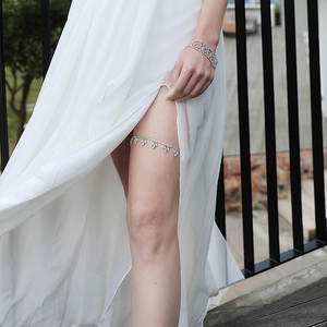 Close-up of sparkling rhinestone wedding garter and matching bracelet on bride