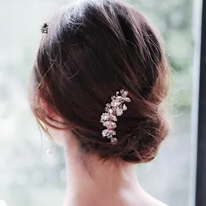 Detailed view of a silver floral hair comb with crystals set in a bridal updo hairstyle