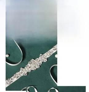 Détail d'une ceinture de mariée faite main avec cristaux et strass sur satin blanc soyeux