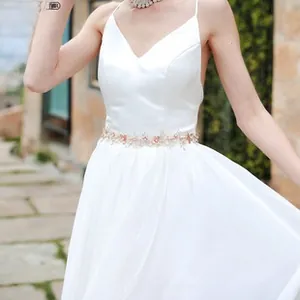 Detail of rose gold sequin and bead floral embellishments on a bridal dress waist belt