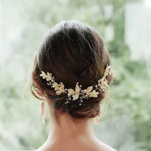 Detailed view of handmade gold leaf and pearl bridal hair comb set in bridal updo