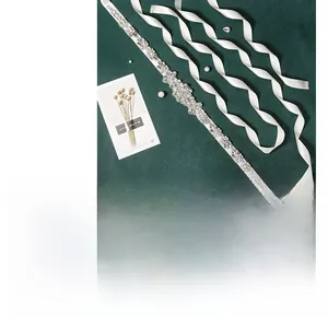 Détail de la ceinture de mariée faite main avec strass floraux et ruban de satin blanc