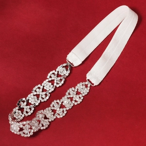 Detailed view of bridal garter with sparkling floral rhinestones and white elastic band