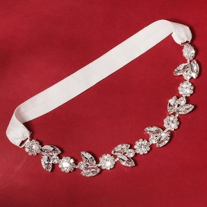 Elegant bridal wedding garter with sparkling crystals and silver leaf patterns on red leather