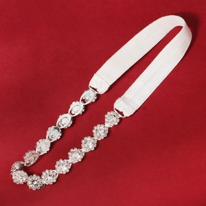 Detail of luxury bridal garter with sparkling rhinestones on red background