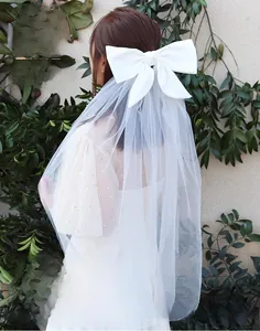 Detail of bridal white bow veil with rhinestones and handmade wire winding craftsmanship