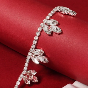 Detail view of silver rhinestone garter with marquise cut crystals on red velvet stand