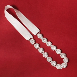 Macro detail of luxury bridal garter featuring sparkling floral rhinestones on white elastic