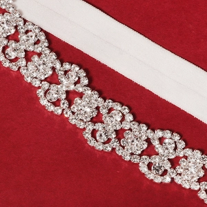 Close-up of bridal garter featuring sparkling floral rhinestones and white elastic band