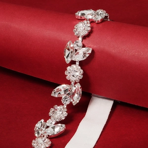 Macro shot of silver bridal garter featuring marquise crystals and flower details