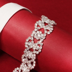 Elegant bridal rhinestone garter with floral pattern on a red display stand