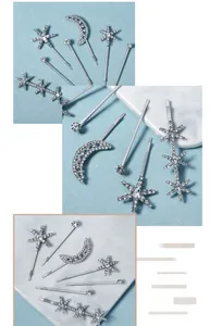 Détail de pinces à cheveux lune et étoile argentées avec strass brillants sur marbre