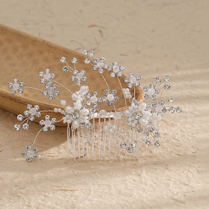 Close-up of handmade bridal hair comb with crystal flowers and white pearls