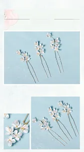 Détail d'épingles à cheveux de mariée avec fleurs en résine blanche et tiges dorées