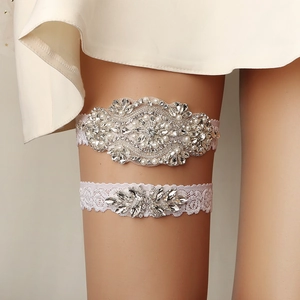 Elegant bridal garter set with white lace, sparkling rhinestones and pearls for weddings