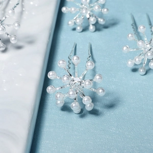 Elegant U-shaped bridal hair pin with radiant pearl cluster on a light blue background