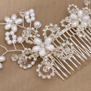 Elegant bridal hair comb with pearls and rhinestones on a vintage textured surface