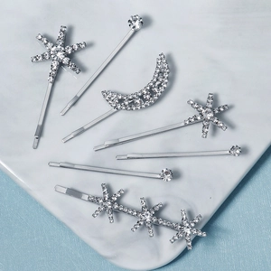 7-piece silver star and moon rhinestone hair clip set on a luxury marble surface