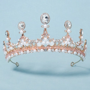 Baroque bridal tiara with rose gold plating, pearls and sparkling crystals on blue background