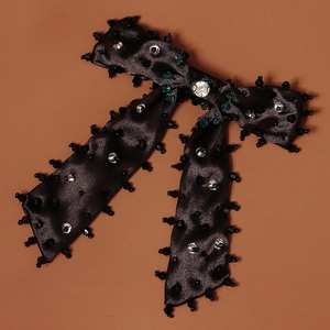 Détail de la pince à cheveux noeud satin noir avec strass et pampilles perlées