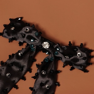 Détail de la pince à cheveux noeud en satin noir avec cristaux et strass bleu océan