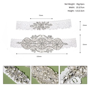 Detail view showing handmade rhinestones and pearls on white lace bridal garters