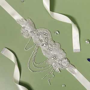 Vue détaillée de la ceinture de mariée avec perles faites main et pompons en strass