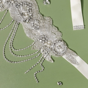 Détail de ceinture de mariée avec perles faites main, strass et franges sur ruban
