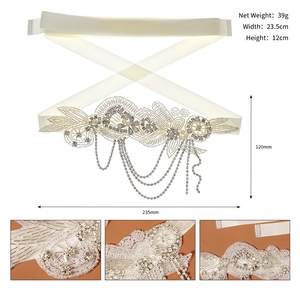 Détail d'une ceinture de mariée faite main avec perles, strass argentés et glands