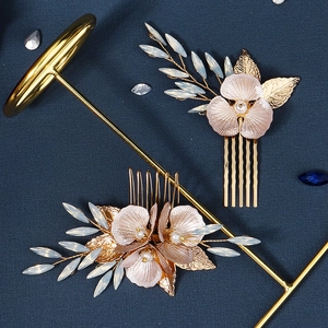 Vue détaillée des peignes à cheveux dorés avec pétales roses et accents de perles