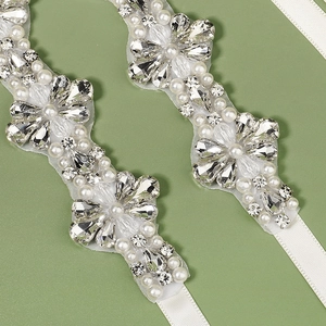 Ceinture de mariée élégante avec perles blanches et strass étincelants sur fond vert