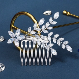 Détail d'un peigne de mariée argenté avec feuilles de zircon et dents en métal brossé