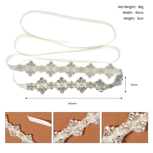 Détails de la ceinture de mariée montrant les strass et perles sur ruban de satin blanc