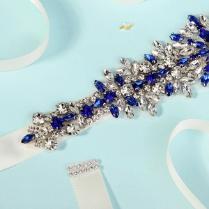 Detail shot of hand-sewn royal blue rhinestones on a white satin bridal wedding belt