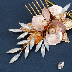Détail d'un peigne à cheveux floral doré avec pétales violets et perles sur fond bleu
