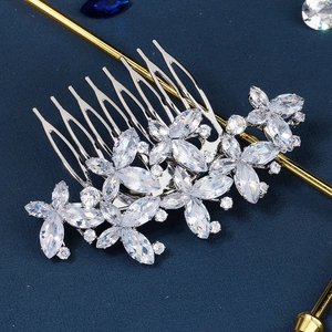 Gros plan d'un peigne de mariée avec fleurs en zircone sur fond bleu marine chic