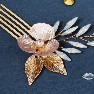 Vue détaillée du peigne à cheveux doré avec fleur rose et perles blanches pour mariée
