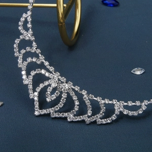 Sparkling silver rhinestone headband with hollow heart designs on dark blue background