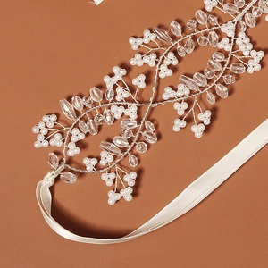 Close-up of handmade bridal headband with silver wire branches, pearls, and crystal beads